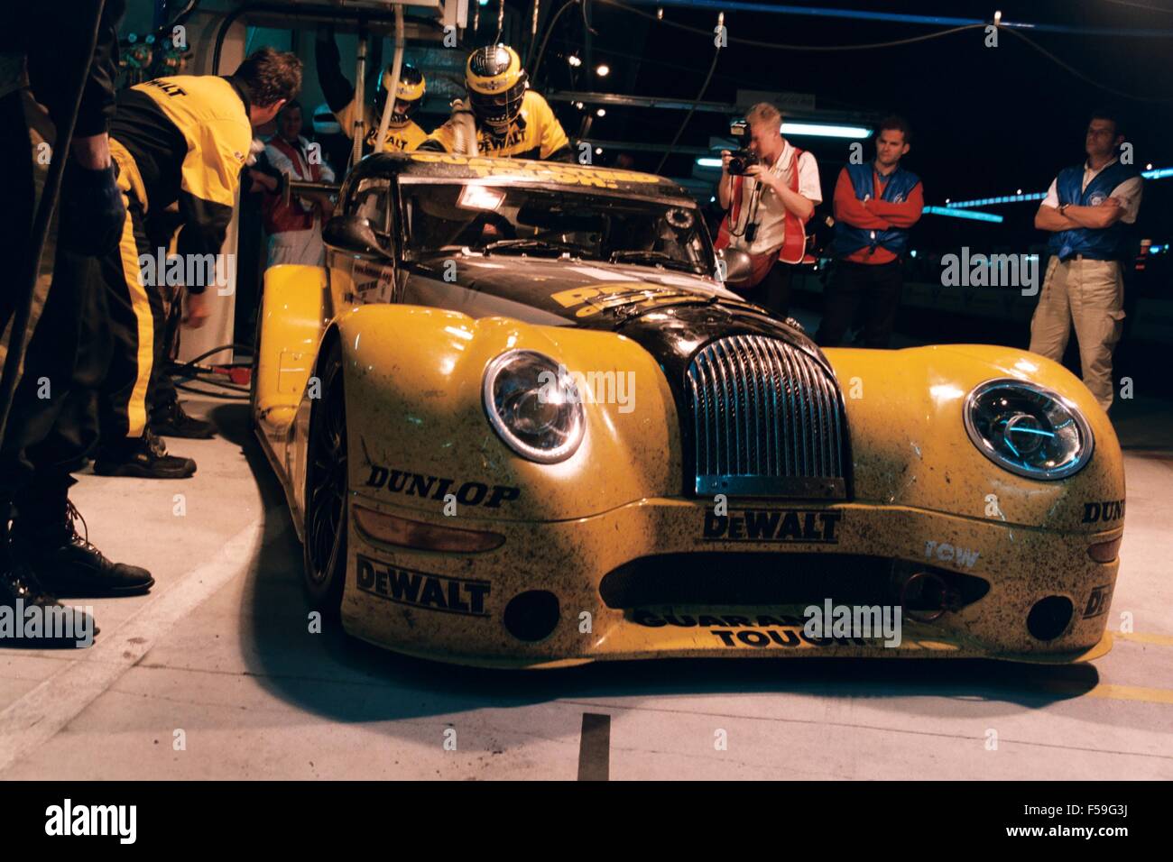 Morgan Aero 8 racing car in giallo dewalt livrea strumenti come guidati nella 24 Ore di Le Mans 2002 e 2004 - Mostra le auto provenienti in pit lane con equipaggio in attesa Foto Stock