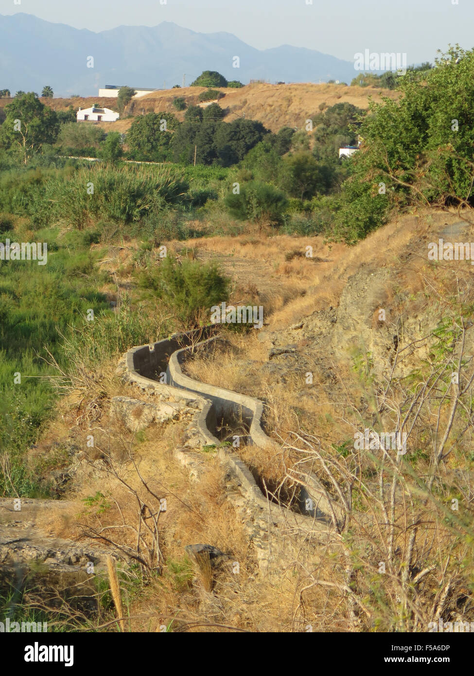 Calcestruzzo canale di irrigazione avvolgimento attraverso campagna vicino a Alora, Andalusia Foto Stock