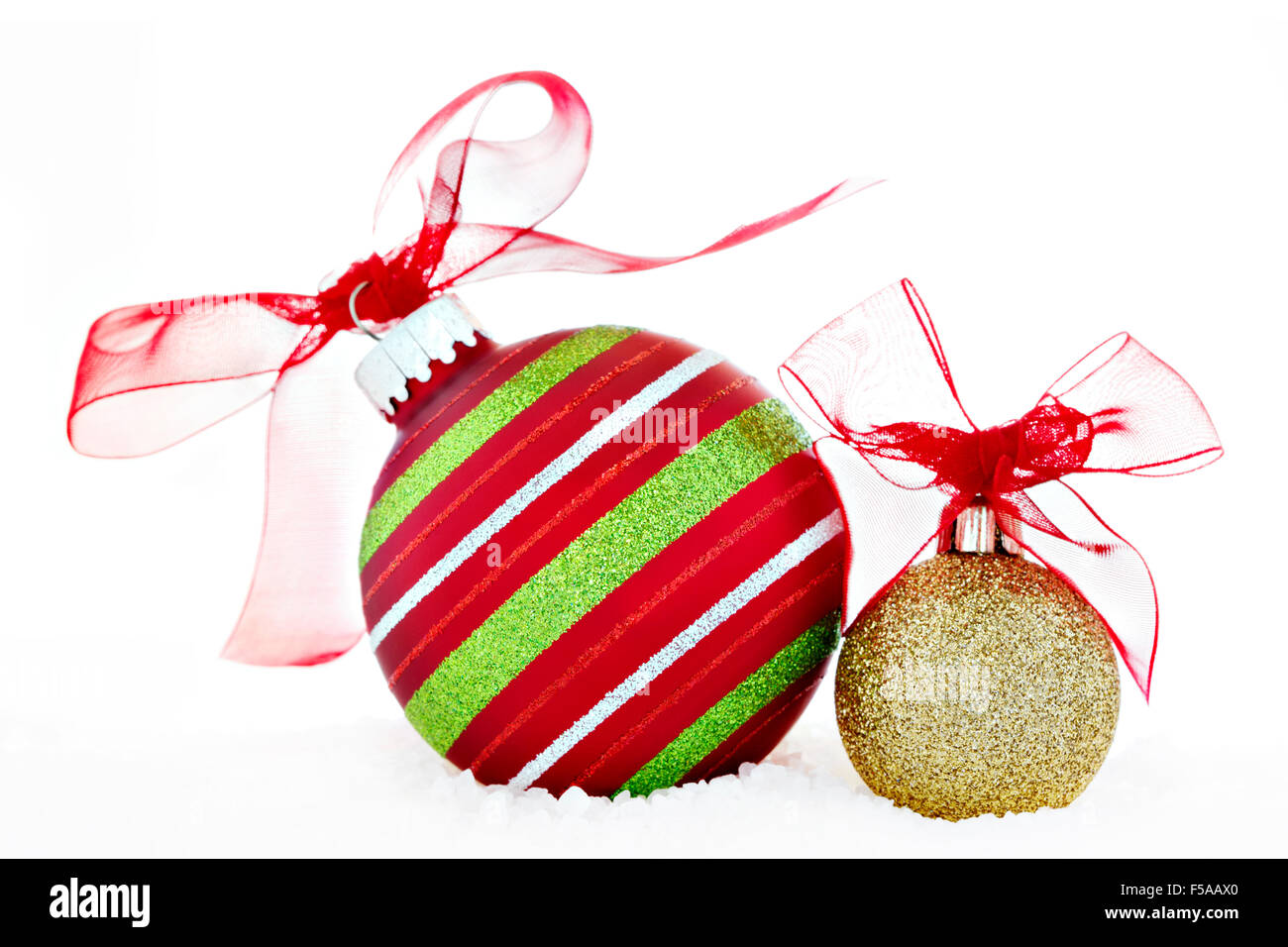 Addobbi natale rosso e oro sfere con nastro rosso posto sulla neve. Decorazione di Natale creative still life fotografia. Foto Stock