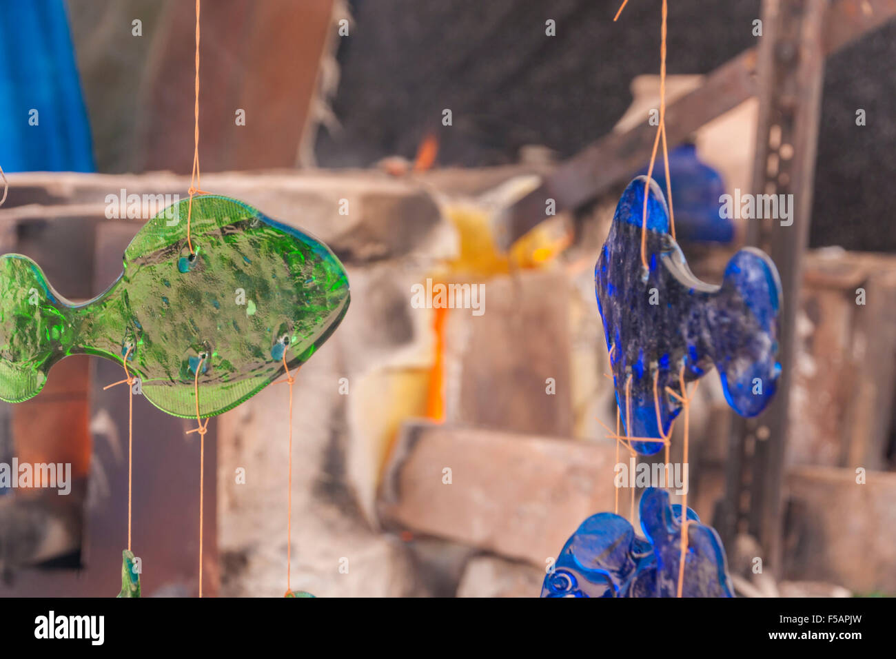 Colorate e fatti a mano il pesce di vetro ad una beduina arte tariffa. Forno per vetro incandescente in background. Foto Stock