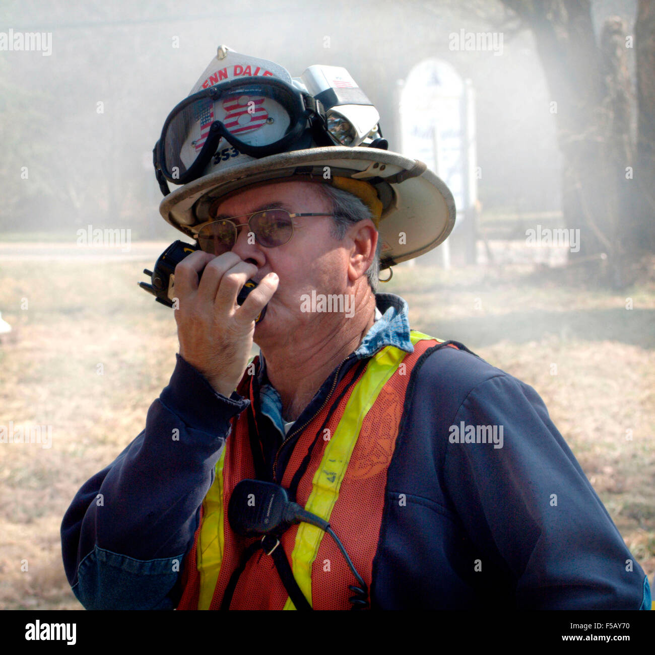 Firefighter comunicazione sulla sua radio a due vie durante un incendio in Glendale, Md... Foto Stock