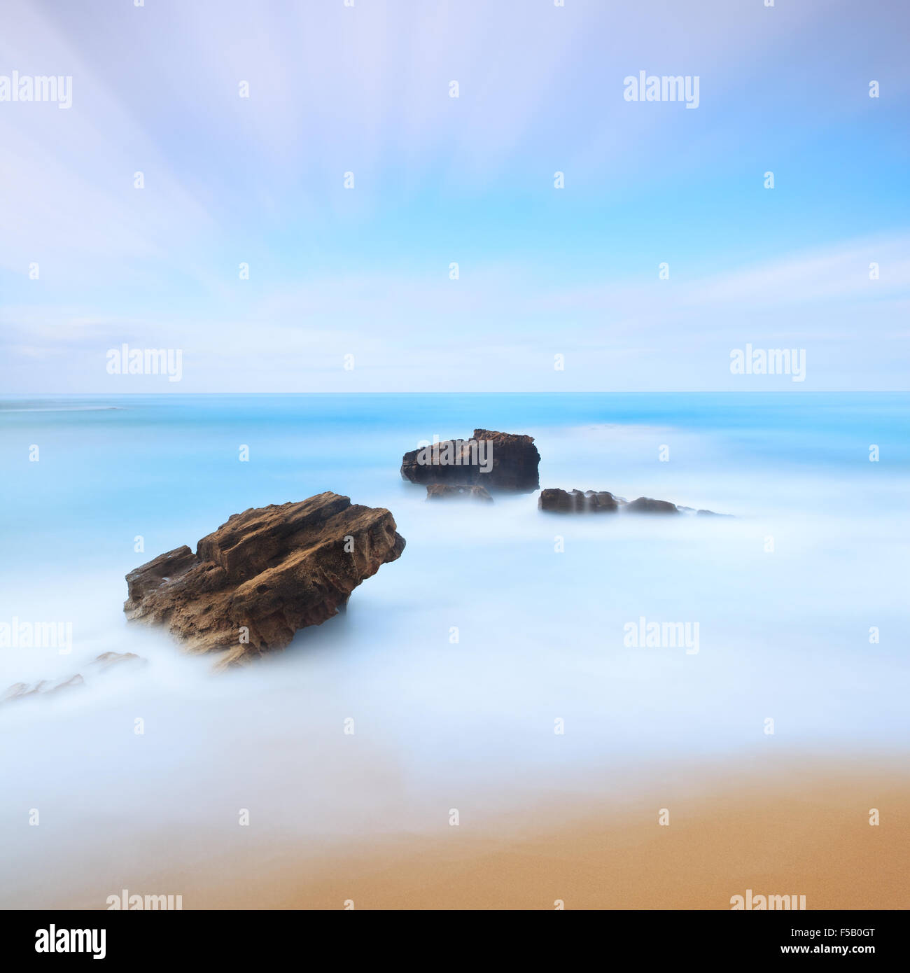 Una lunga esposizione fotografia con tre pietre presi in inverno sulla costa toscana, Italia. Foto Stock