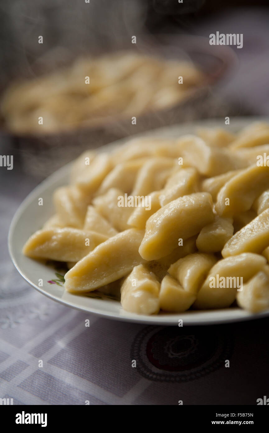 Fumante piatto kopytka, bollito kopytka cibo di impasto su una piastra in cucina tradizionale polacca cibo cucinato pezzi e vapore Foto Stock