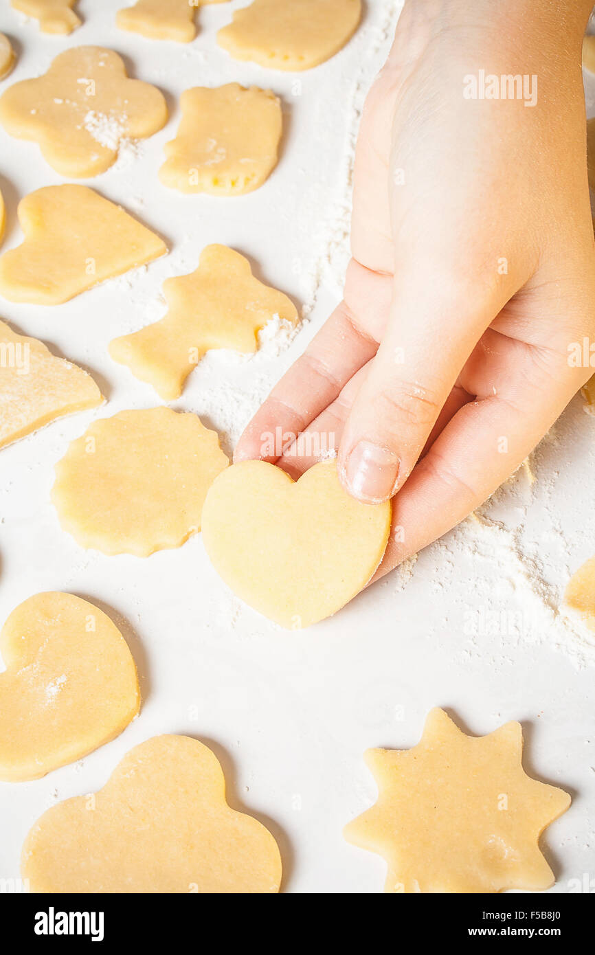 Ragazza mostra forma di cuore al di fuori della pasta, vista dall'alto Foto Stock