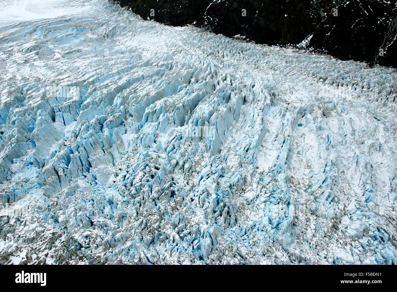 Volo sopra il ghiacciaio Fox che mostra il terreno di ghiaccio nella valle che alle pendici del Westland Tai Poutini National Park, Isola del Sud, Nuova Zelanda Foto Stock
