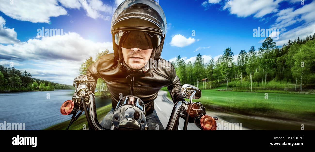 Biker in casco e giacca di pelle racing su strada. Filtro applicato in post-produzione. Foto Stock Biker in casco e giacca di pelle racing su strada. Filtro applicato in post-produzione. Foto Stock