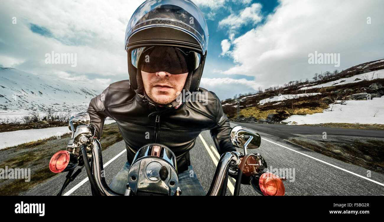 Biker in casco e giacca di pelle racing sulla serpentina di montagna. Foto Stock Biker in casco e giacca di pelle racing sulla serpentina di montagna. Foto Stock