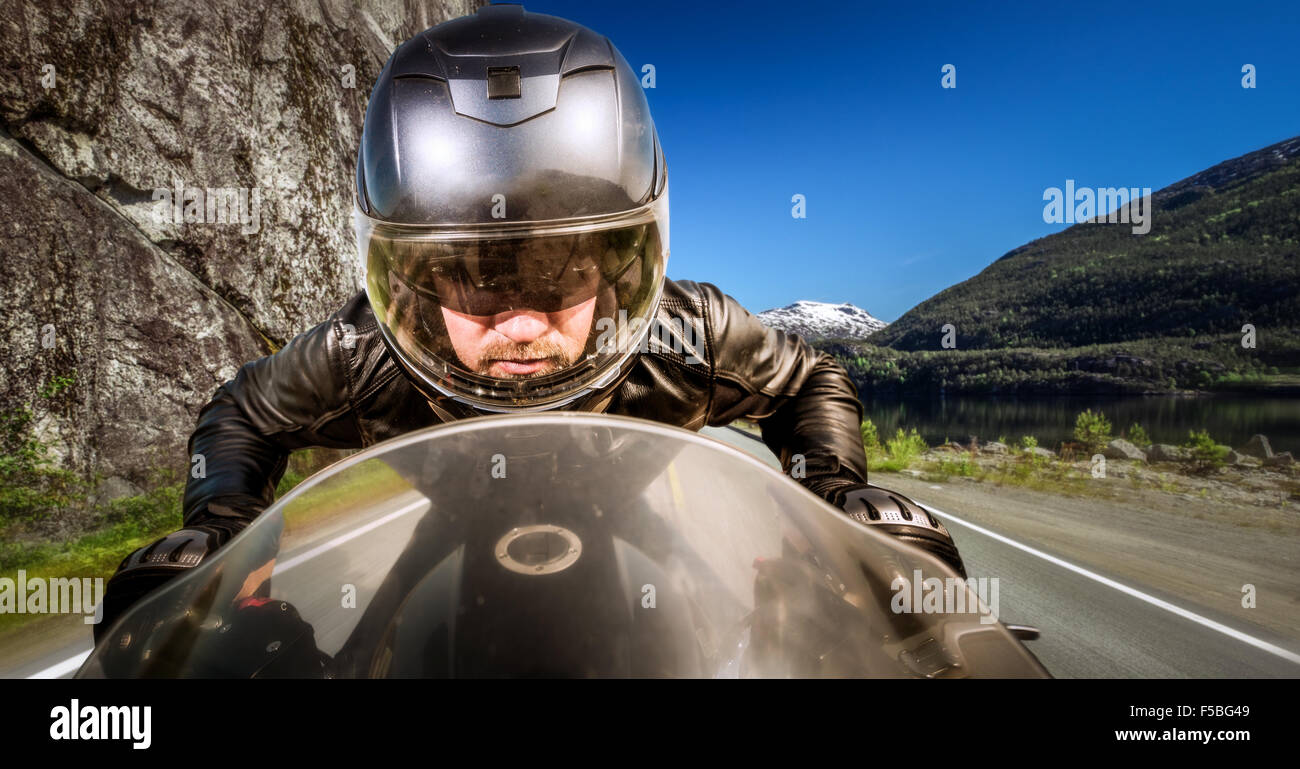 Biker in casco e giacca di pelle racing su strada. Foto Stock Biker in casco e giacca di pelle racing su strada. Foto Stock