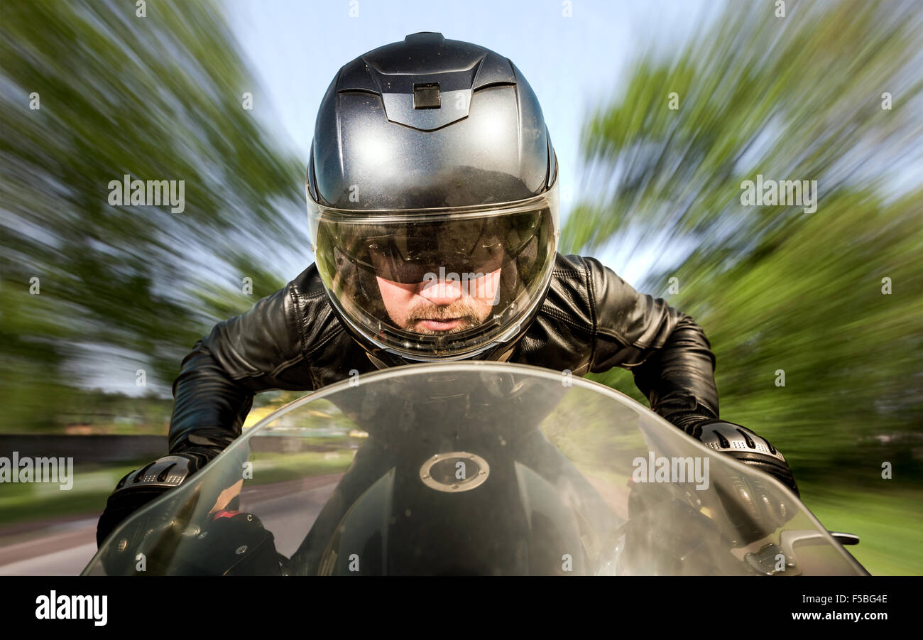 Biker in casco e giacca di pelle racing su strada. Foto Stock Biker in casco e giacca di pelle racing su strada. Foto Stock