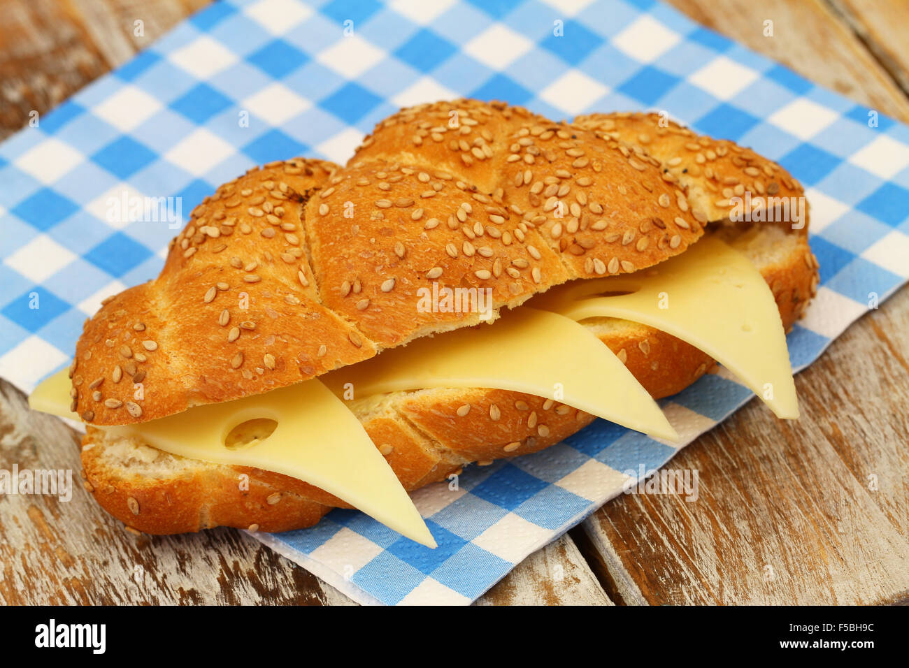 Semi di sesamo challah in sandwich con formaggio a scacchi sul tovagliolo di carta Foto Stock