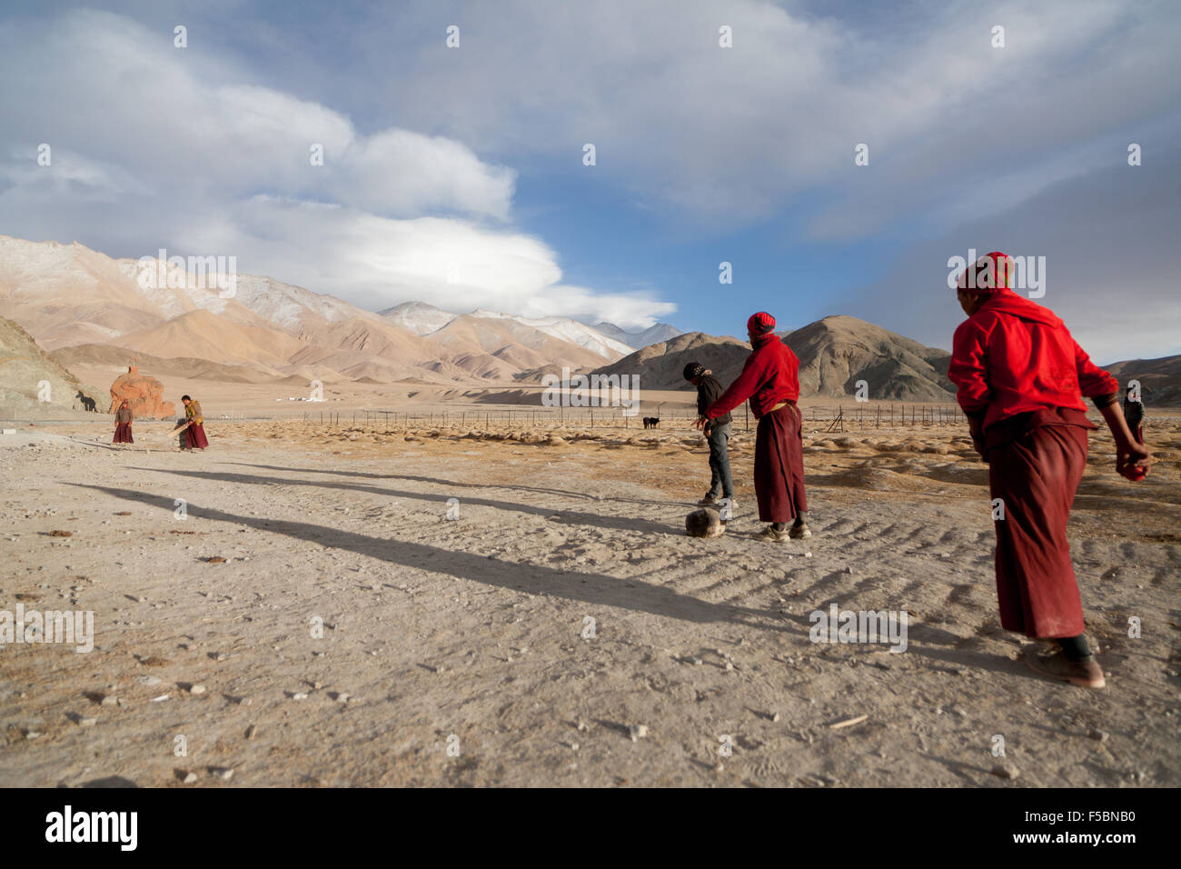 I monaci del monastero di Hanle giocando una partita amichevole di cricket nel freddo inverno Ladakhi. Foto Stock