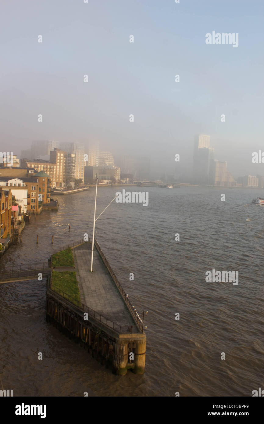 Londra, Regno Unito. 1 novembre 2015. Una fitta nebbia dei rotoli di nuovo da est a coprire il Docklands e nascondere i suoi grattacieli di riferimento. La nebbia continua ad est oltre Rotherhithe, rendendo per un eeir tramonto sul fiume Tamigi. 1 novembre 2015. Credito: Glenn Sontag / Alamy Live News Foto Stock