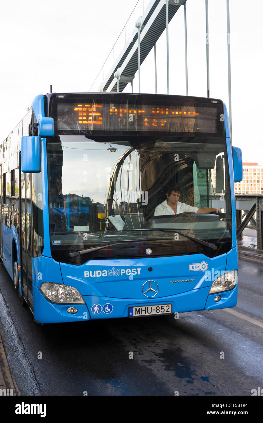Un autobus blu con passeggeri attraversando il ponte delle catene a Budapest, Ungheria. Foto Stock
