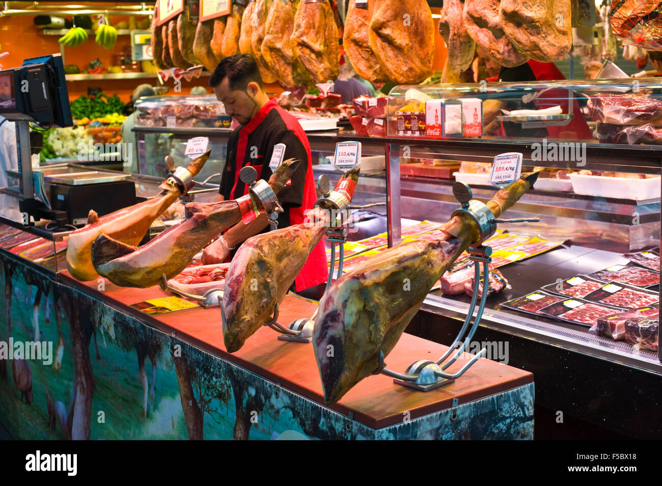 Stalle che vende prosciutto spagnolo tradizionale al mercato la Boqueria di Barcellona Catalonia Spagna ES Foto Stock