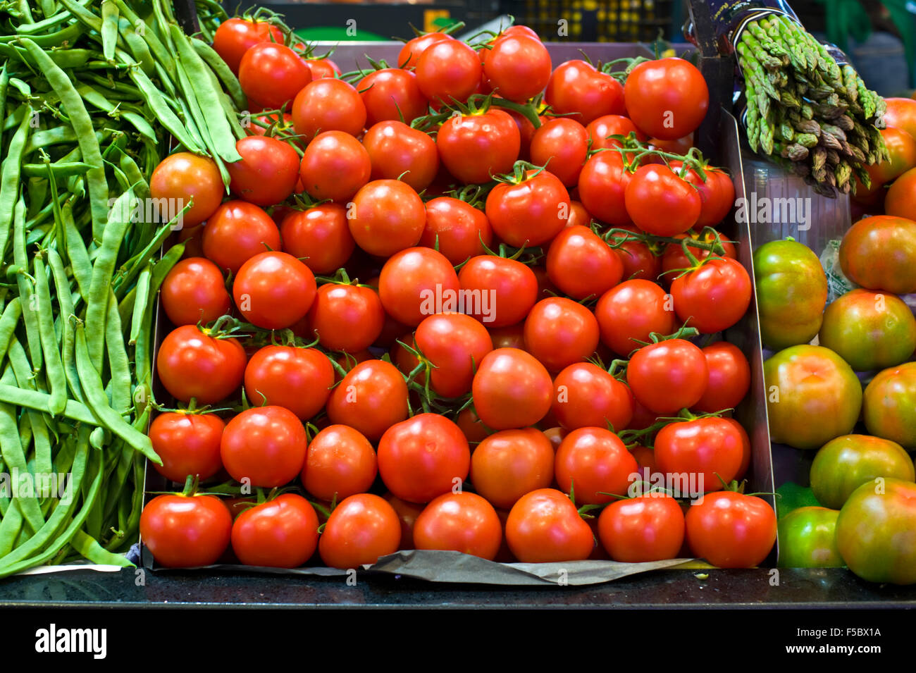 Bancarella di insalata che vende pomodori fagioli e asparagi a mercat la Boqueria mercato Barcellona Catalonia Spagna ES Foto Stock