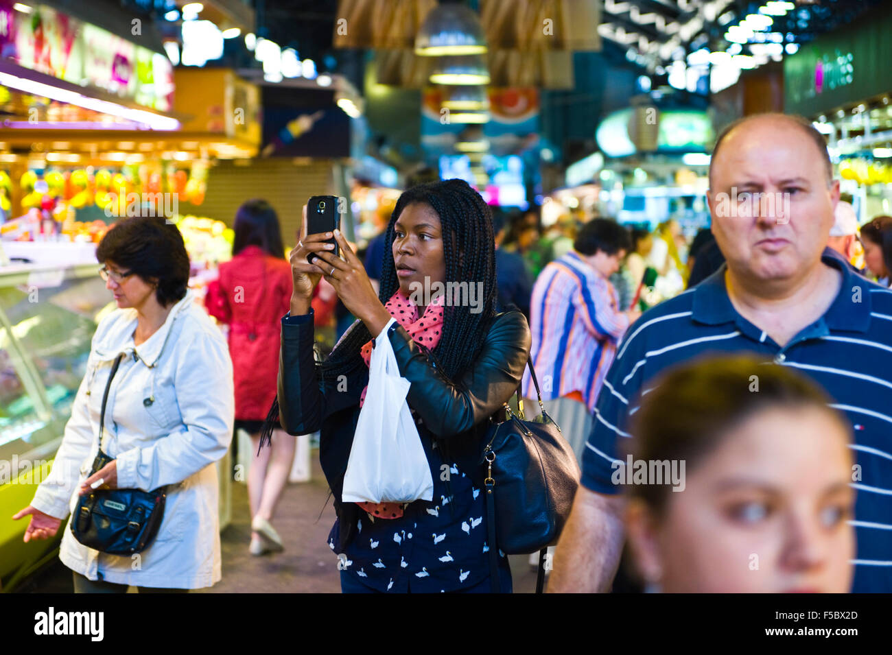 Turistica prendendo le foto con lo smartphone nel mercato La Boqueria Barcellona Catalonia Spagna ES Foto Stock