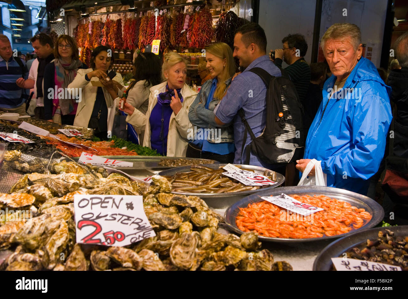 I turisti di mangiare le ostriche sulla molluschicoltura in stallo il Mercato della Boqueria Las Ramblas Barcellona Catalonia Spagna ES Foto Stock