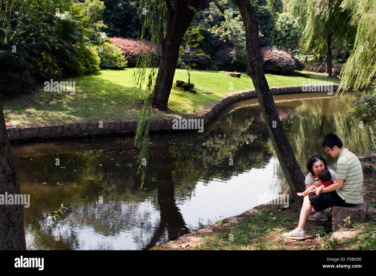 Famiglia di riposo in una zona verde in Shanghai Zoo. Lo Zoo di Shanghai è il principale il giardino zoologico nel distretto di Changning in mento Foto Stock