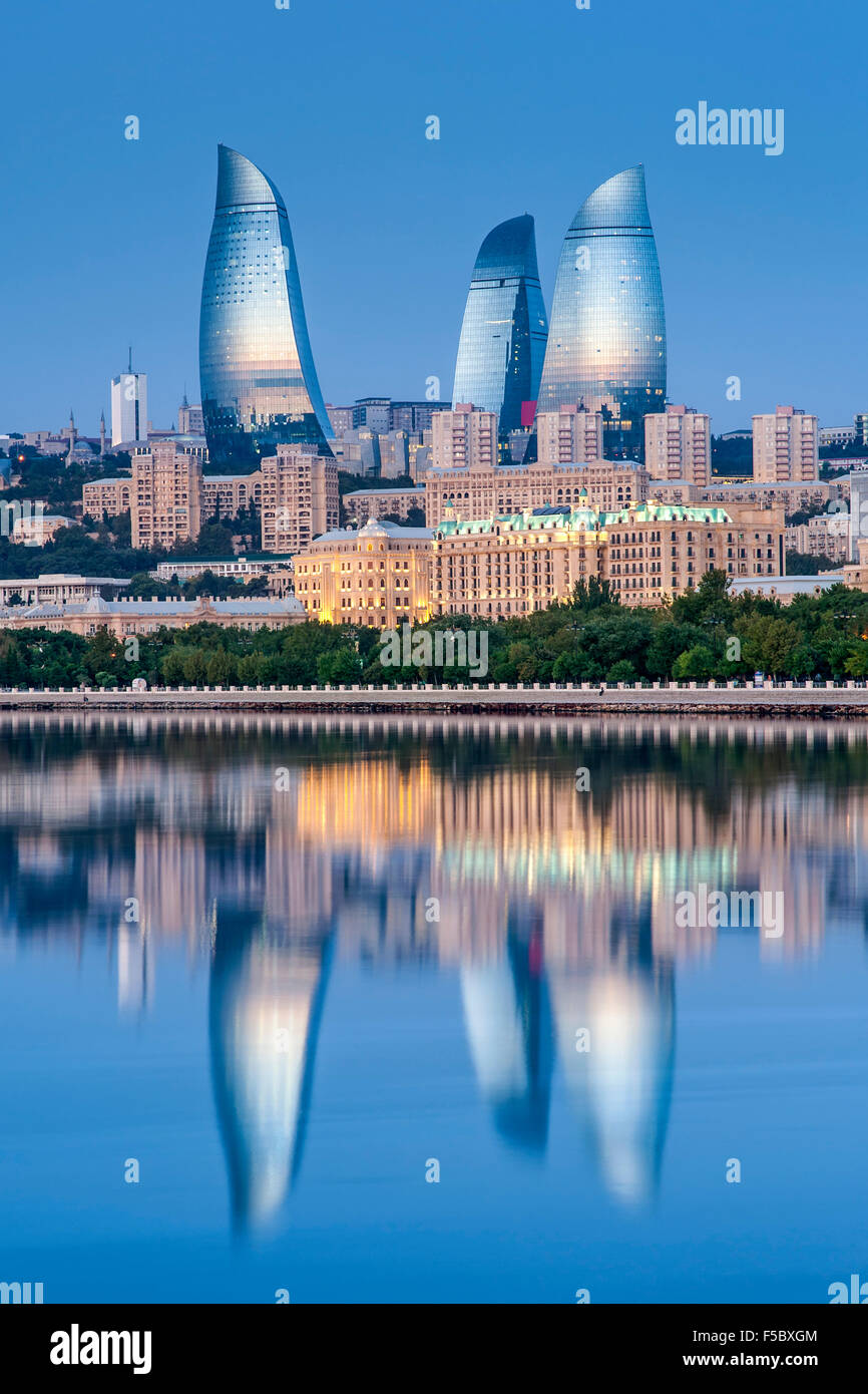 Le torri a fiamma riflessa nelle acque della baia di Baku all'alba. Foto Stock