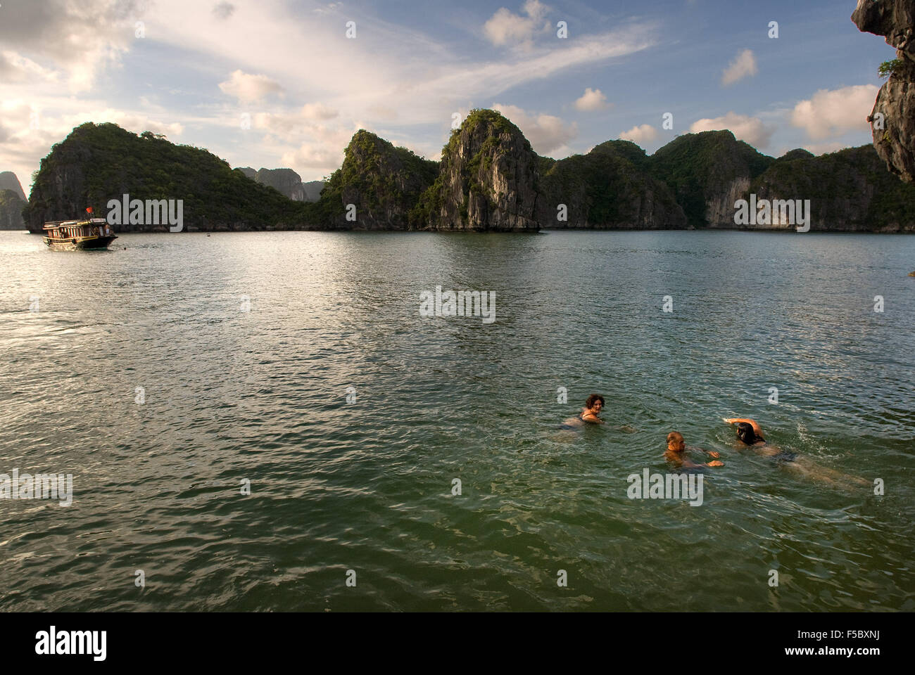 Persone swmming in spiaggia appartata nell isola nella baia di Ha Long, Vietnam. Tranquilla spiaggia tropicale, Cat Ba National Park, Ha long Foto Stock