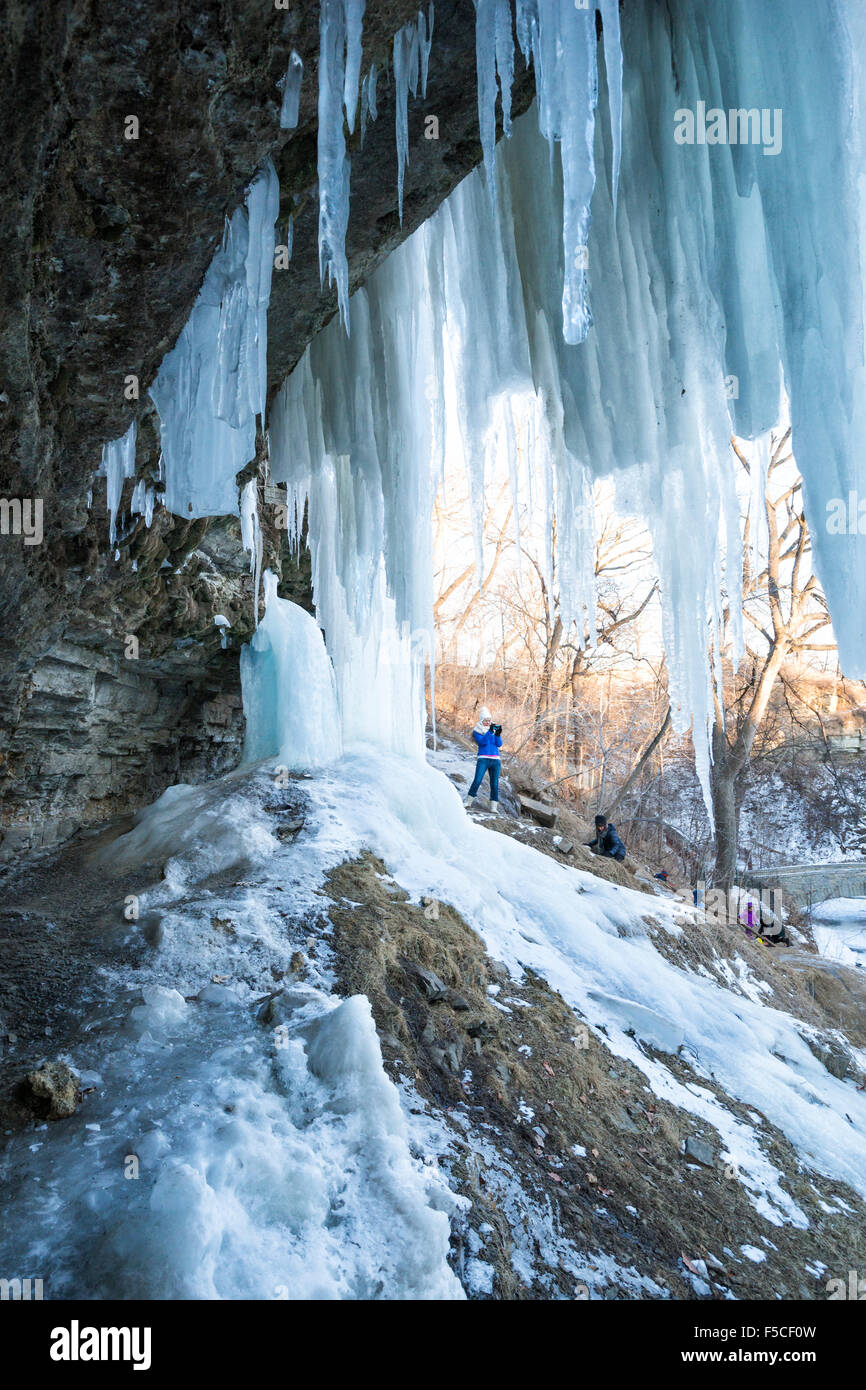 Persone salendo più insidioso percorso che conduce all ingresso dietro il congelato cascate Minnehaha in inverno, Minneapolis, MN, Foto Stock