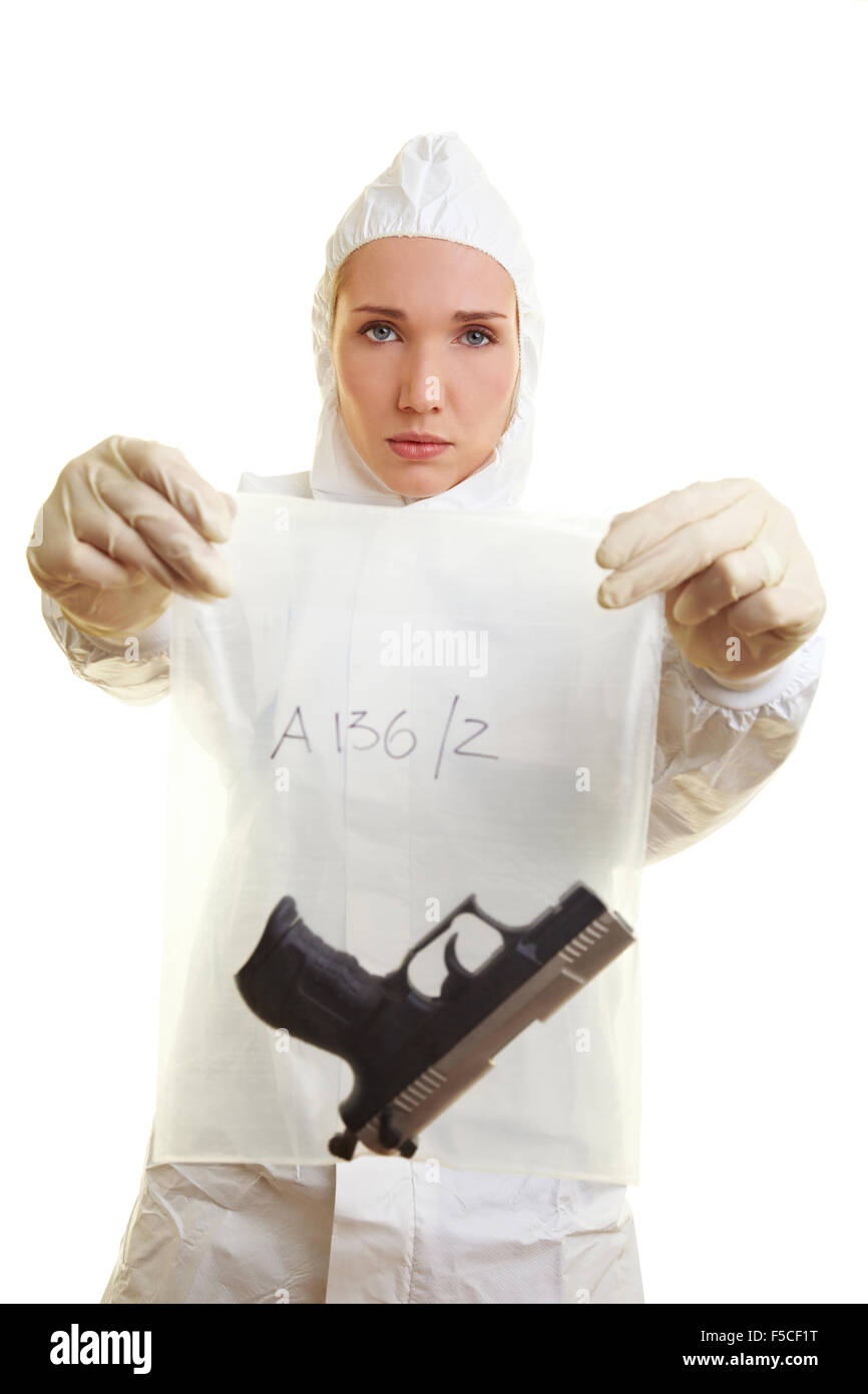 Femmina scienziato forense tenendo un arma come elemento di prova Foto Stock