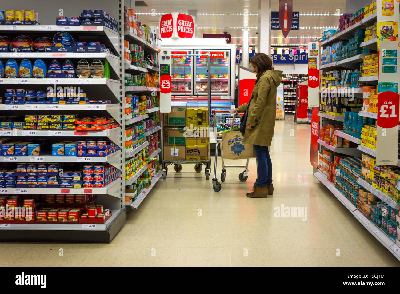 Donna shopping in un Sainsbury's supermercato conserve di verdura display Foto Stock