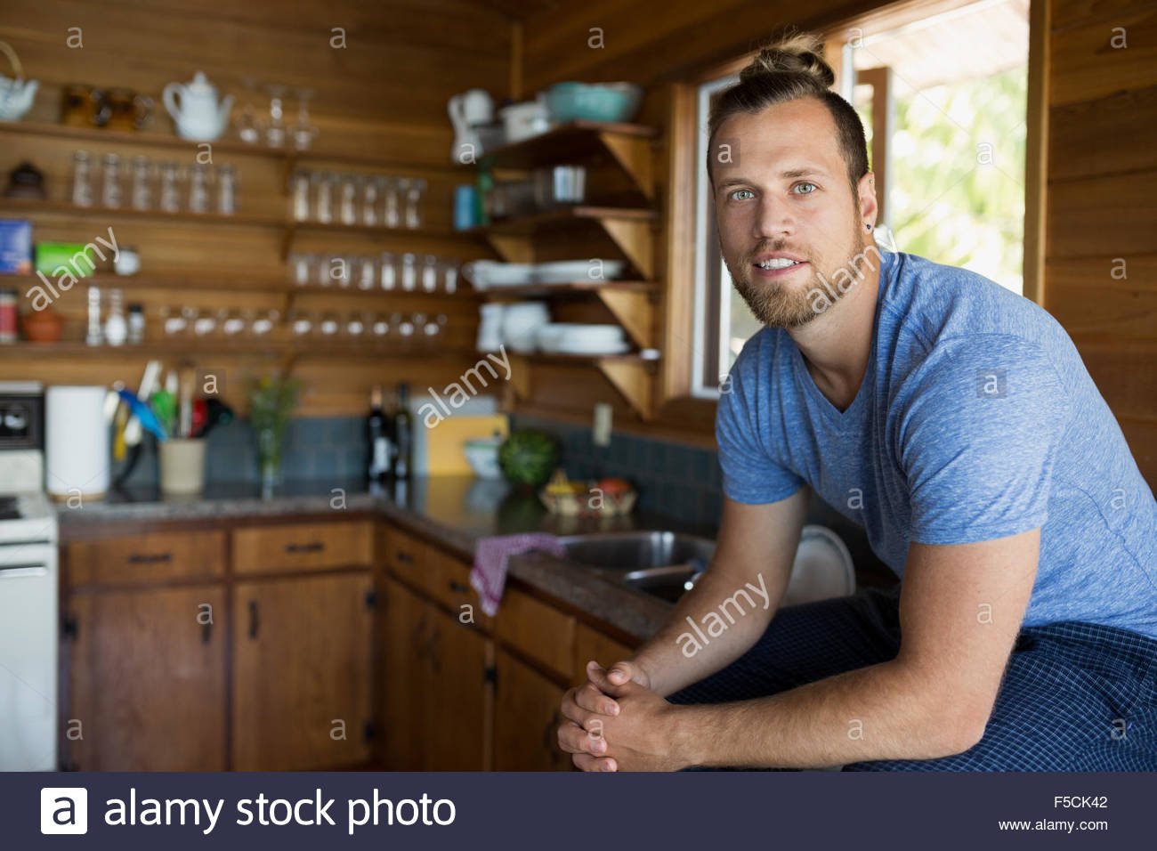Ritratto giovane uomo seduto in cabina cucina Foto Stock
