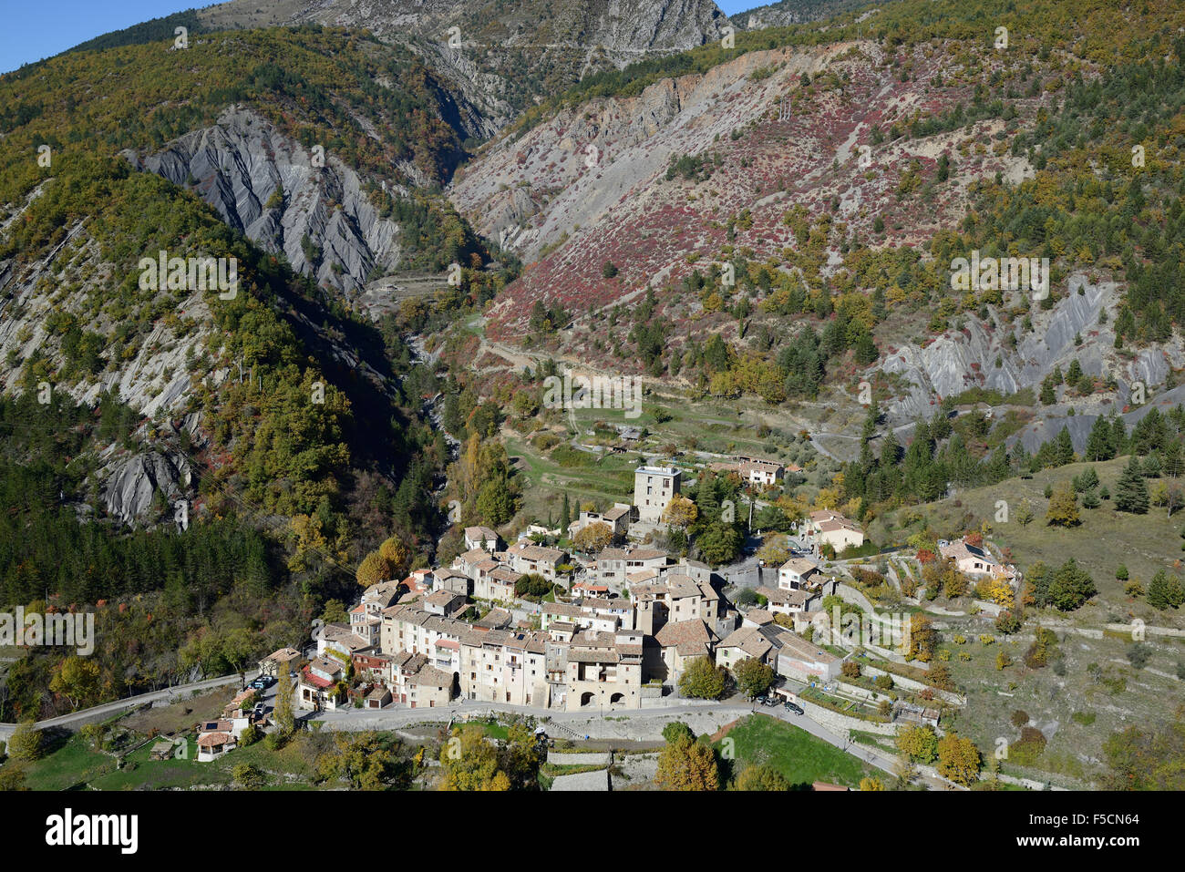 VISTA AEREA. Borgo arroccato con un paesaggio geologicamente interessante. Puget-Rostang, Alpes-Maritimes, il backcountry della Costa Azzurra, Francia. Foto Stock