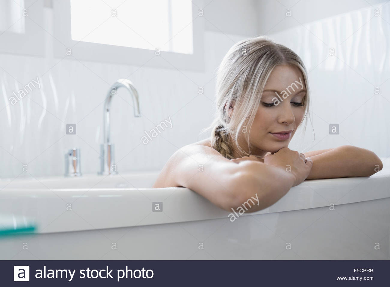 Donna calma rilassante nella vasca da bagno Foto Stock