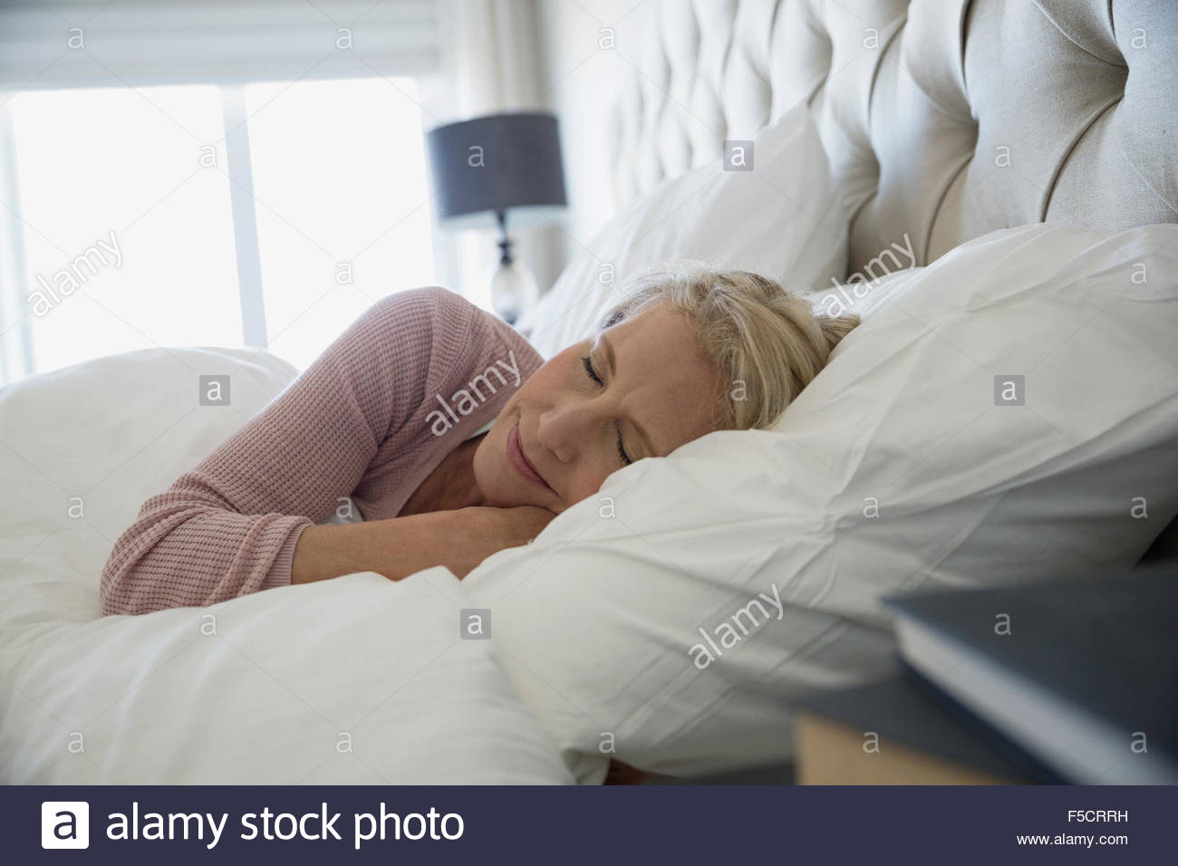 Confortevole donna che dorme nel letto Foto Stock