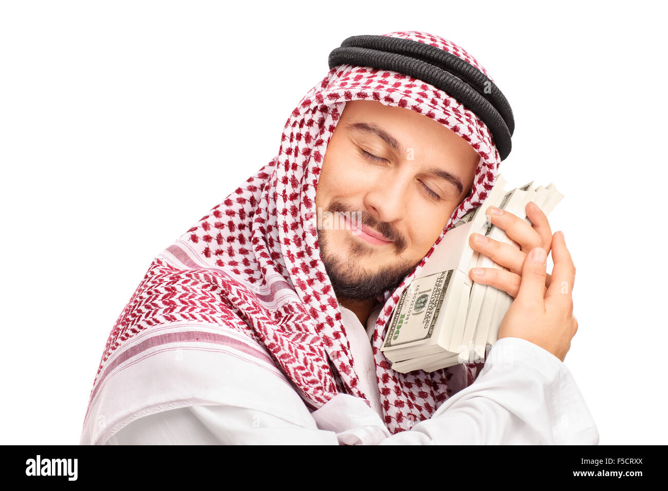 Close-up su un giovane maschio Arab persona che dormiva sul denaro e sorridente isolati su sfondo bianco Foto Stock