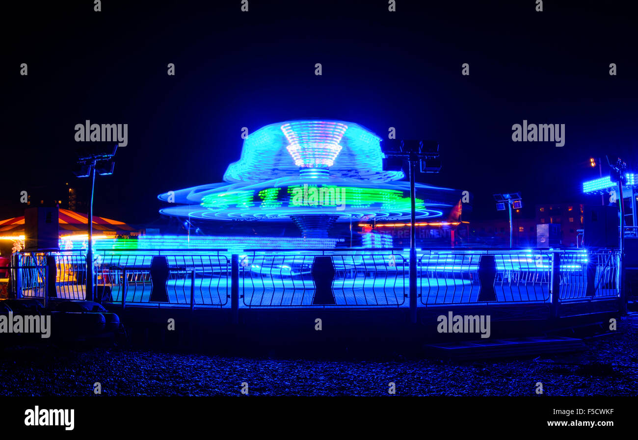 Fairground Ride, Sizzler, di notte, offuscata dalla filatura intorno a. Foto Stock