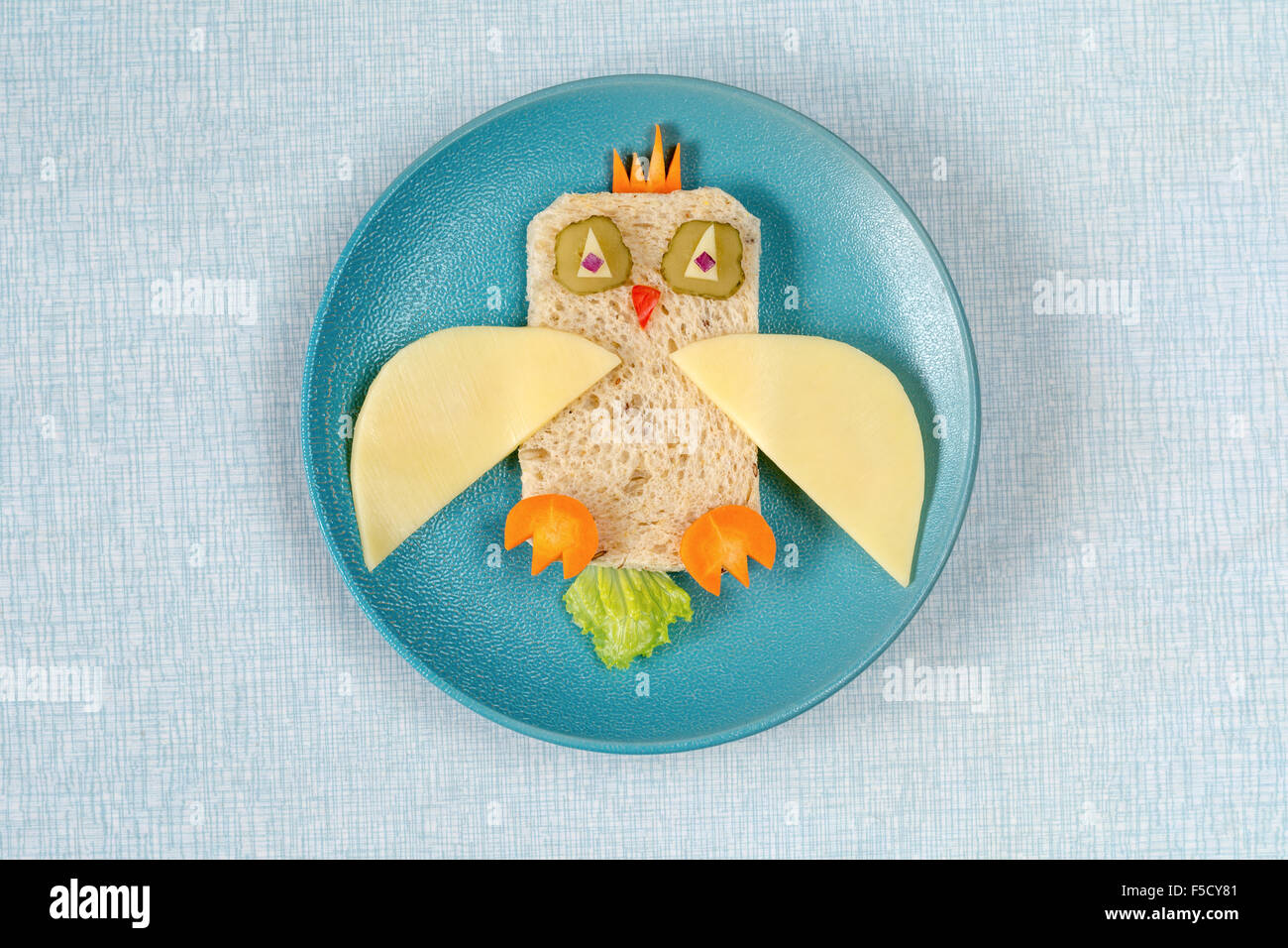 Divertente gufo sandwich per bambini sulla piastra e sana colazione o pranzo a scuola. Isolato su blu Foto Stock