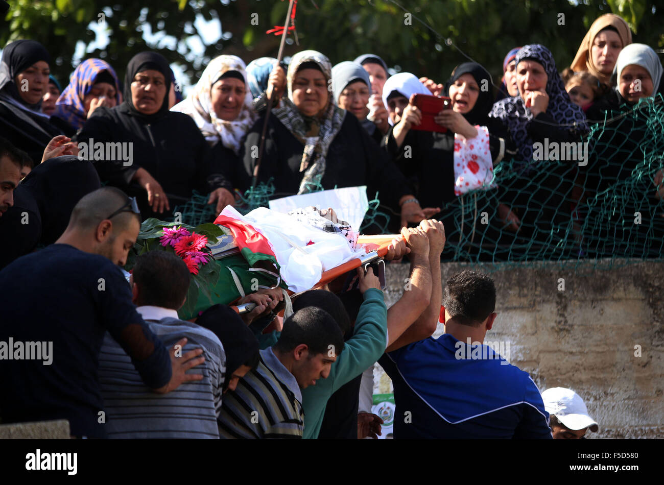 Qatana, West Bank, Territorio palestinese. 2° Nov, 2015. Palestinesi lutto portano il corpo dei loro compagni di Omar palestinese Al Faqih durante il suo funerale nel villaggio di Qatna, ad ovest di Gerusalemme, 02 novembre 2015. Autorità israeliane hanno rilasciato i corpi di due attaccanti palestinese solo su 01 Novembre dopo aver chiesto l' Autorità palestinese per garantire che la calma è conservato durante i funerali. Israele ha chiesto che i funerali essere condotta a tarda notte e con la partecipazione limitata a membri della famiglia. Questa politica, i funzionari dicono che dovrebbero mantenere gli aggressori dall essere glorificato e ridurre t Foto Stock