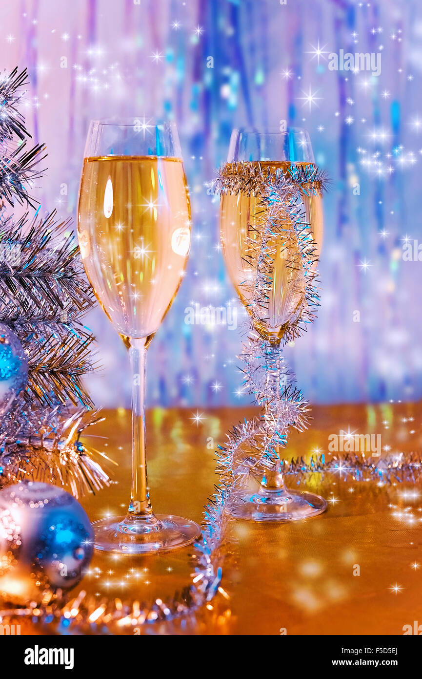 Bicchieri di vino, tinsel, albero di Natale e giocattoli sulla superficie d'Oro Foto Stock