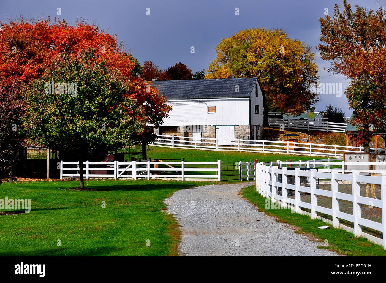 Lancaster, Pennslvania: Bianco recinzioni, sentieri, alberi con fogliame di autunno e le vecchie attrezzature agricole capannone * Foto Stock
