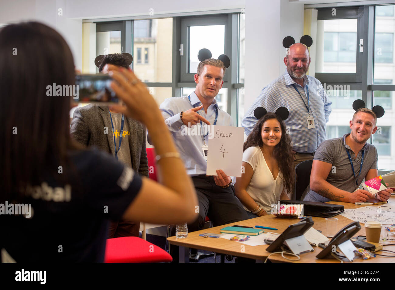 Il imprenditoriale scintilla-small business il giorno di addestramento al Trinity Quay, Bristol - squadre indossare il brainstorming Mickey Mouse orecchie whil Foto Stock