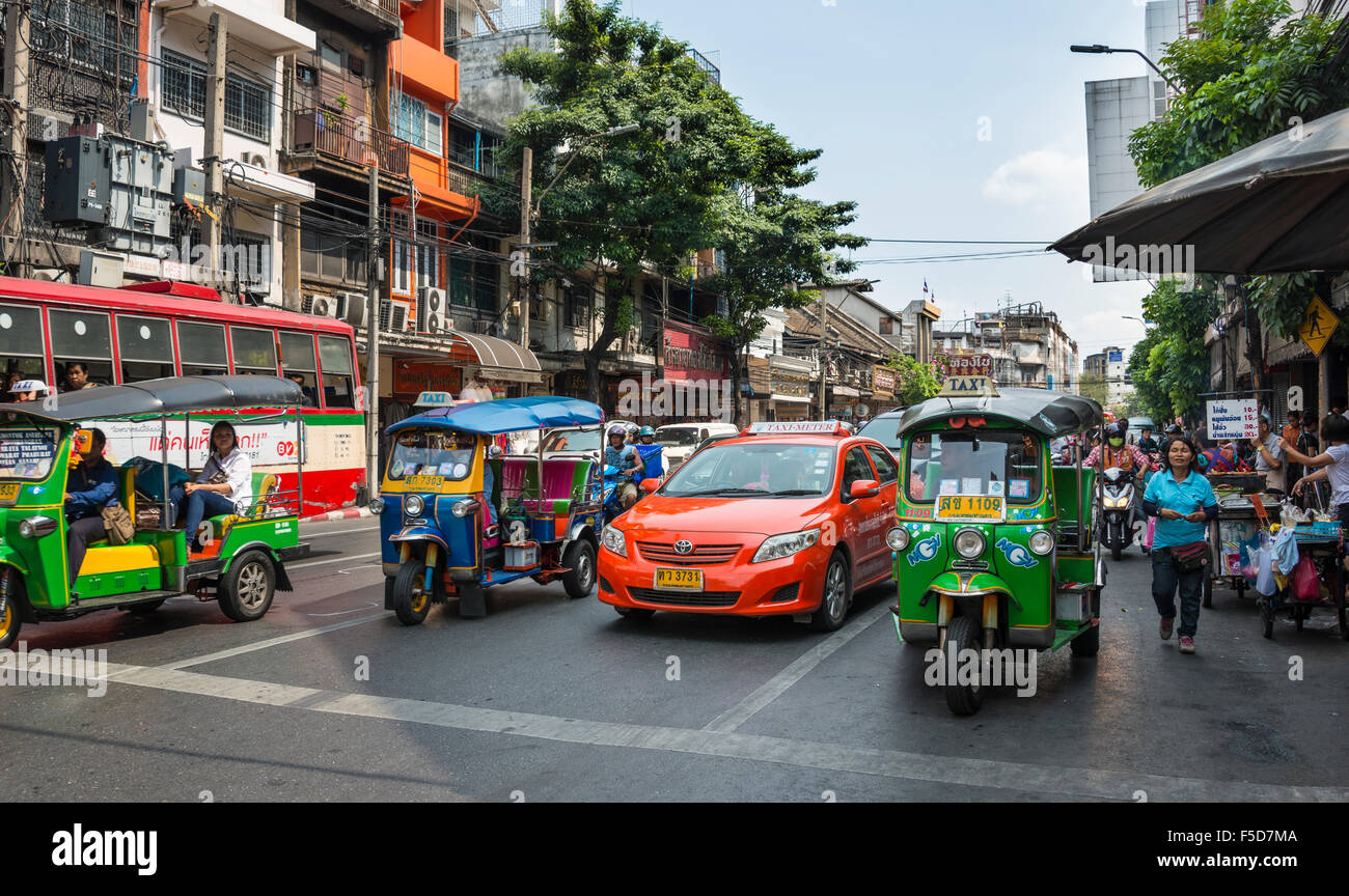 Scena di strada, di tuk-tuks e taxi in attesa ad un semaforo, Bangkok, Thailandia Foto Stock