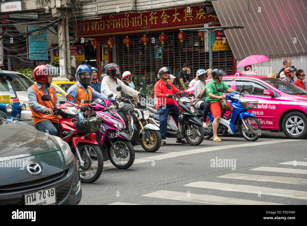 Scena di strada, scooter in attesa in attraversamento su strada trafficata, traffico, Bangkok, Thailandia Foto Stock
