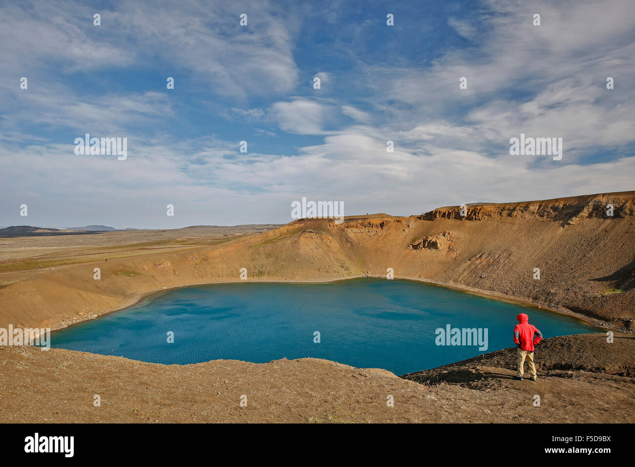 Escursionista ammirando il cratere di esplosione Viti, Vulcano Krafla, vicino Reykjahlid, Islanda Foto Stock