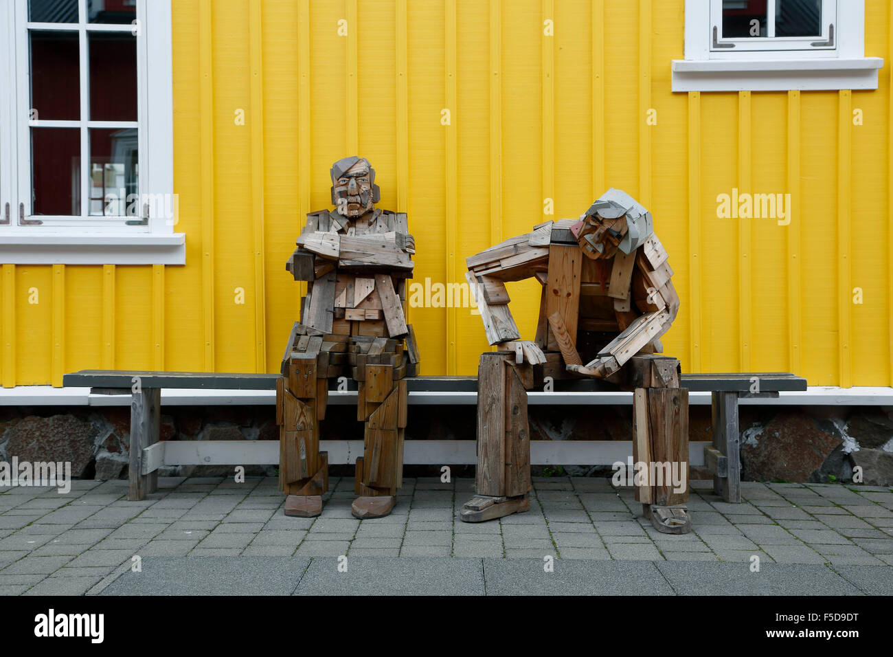 Scultura in legno di due uomini su un banco, Siglufjörður Affitto, Islanda Foto Stock
