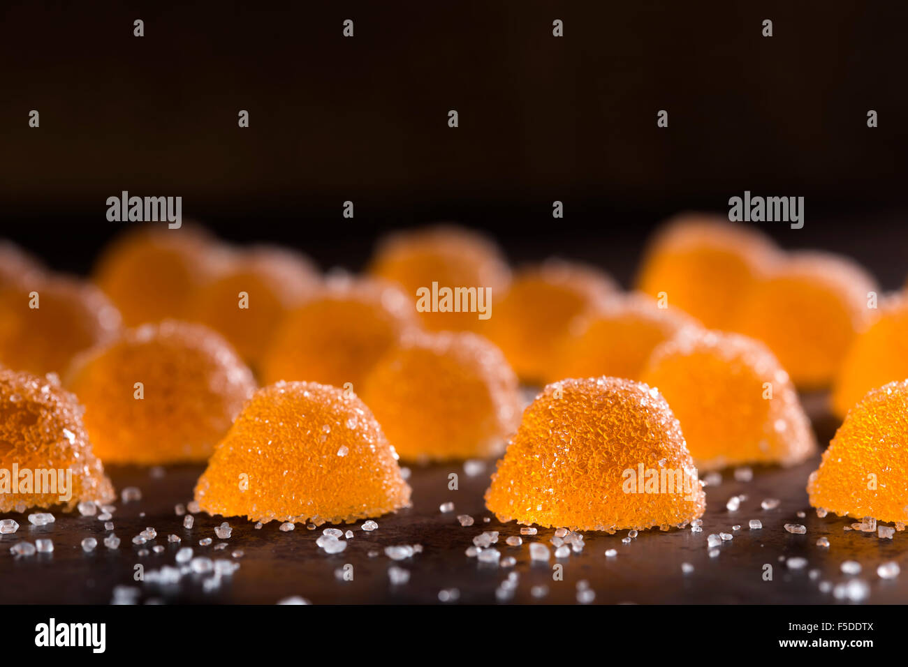 Close-up di colorati gelatina di arancia canditi con zucchero bianco Foto Stock