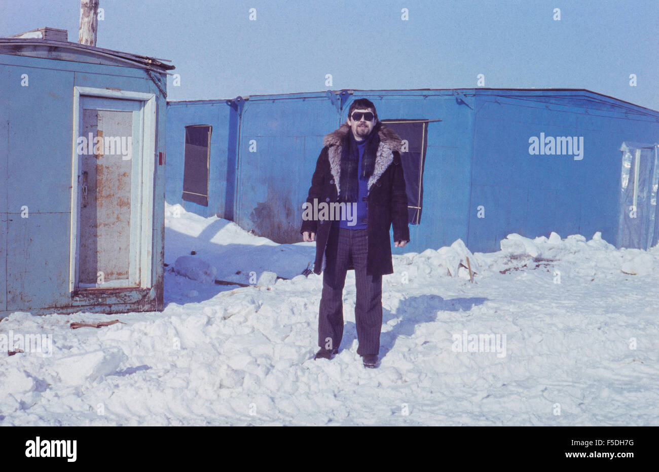 Vintage foto con il giovane uomo vicino a capanne remoto nella tundra dove oro sovietico-escavatrice live durante il lavoro su campo oro Foto Stock
