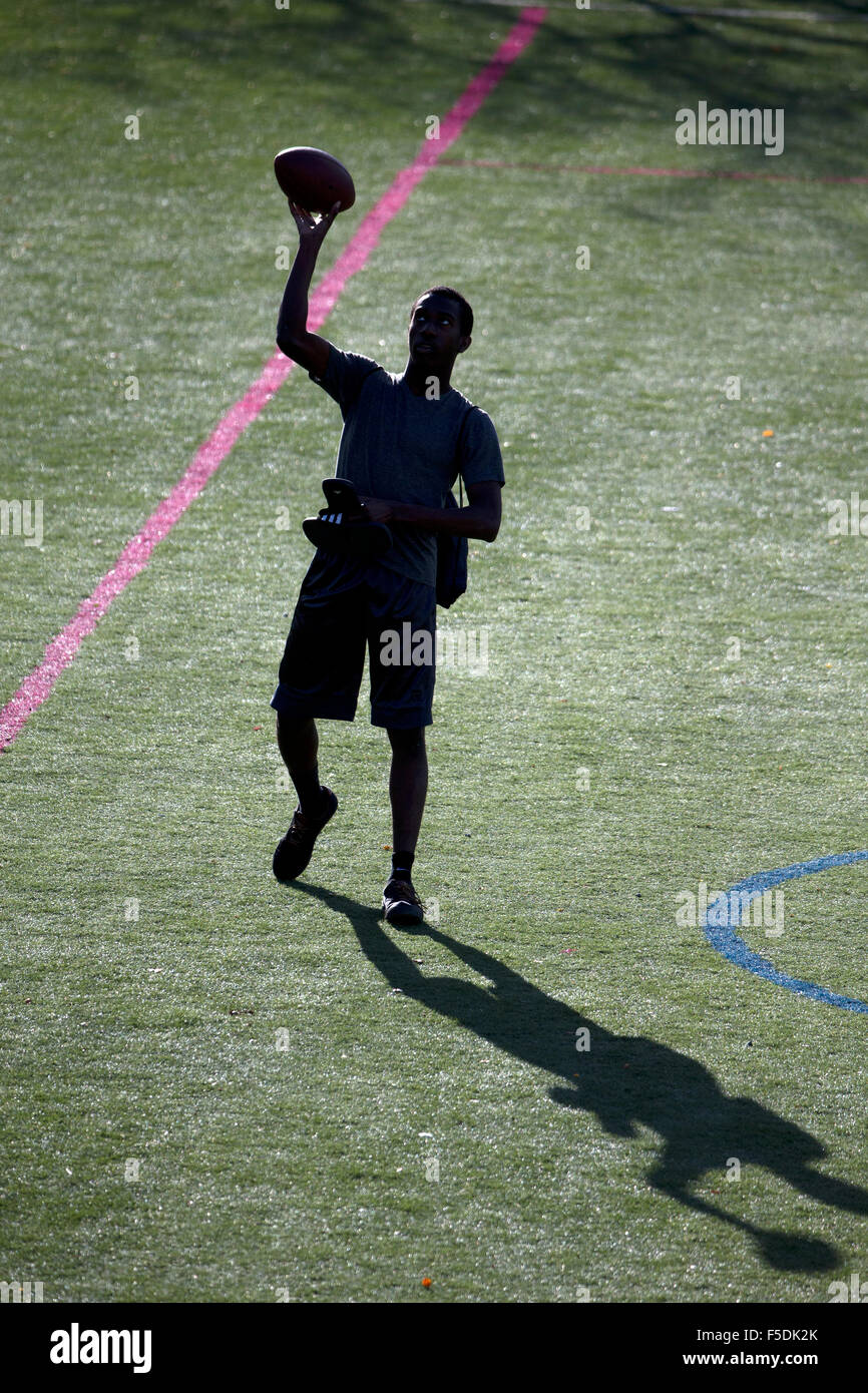 Uomo di gettare un pallone da calcio Foto Stock