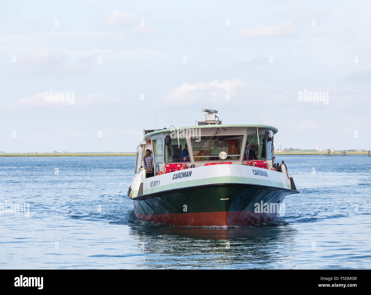 Persone su Venice water taxi approssimarsi al Dock Foto Stock