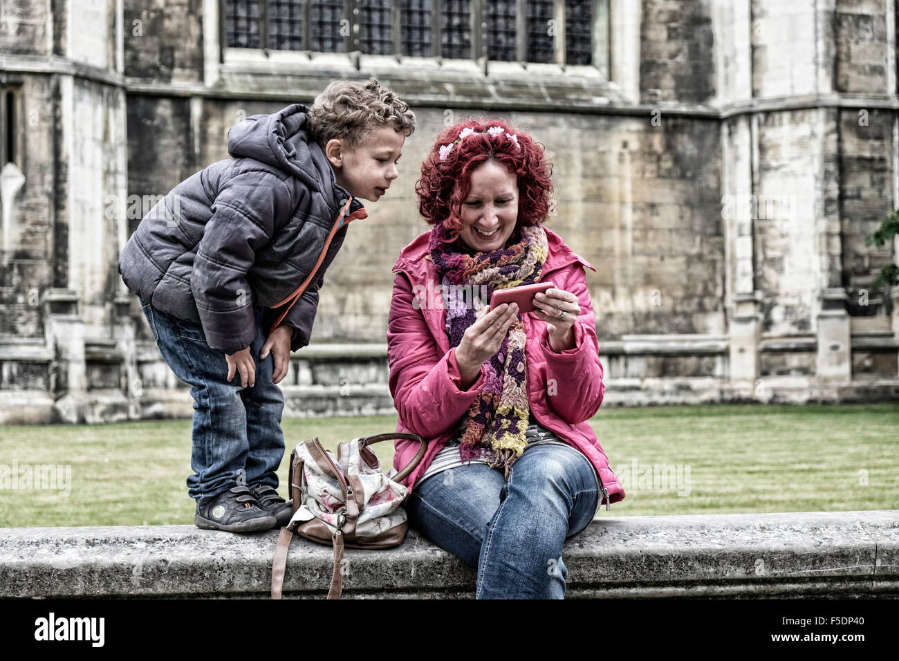 La madre e il figlio di 5 anni guardando al telefono cellulare Foto Stock