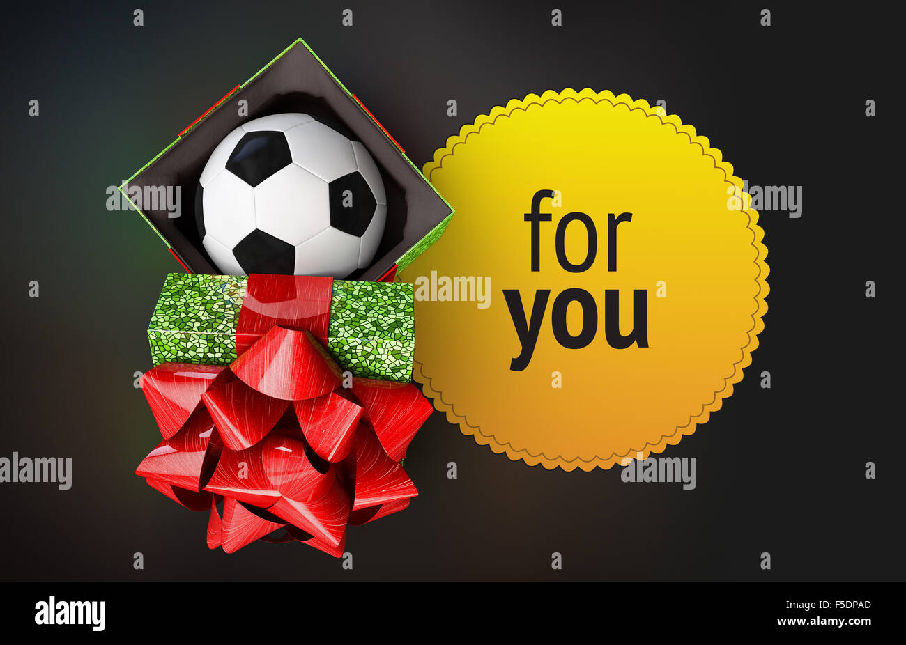 Pallone da calcio a shiny confezione regalo mosaico verde texture vista dall'alto. coperchio decorato bellissimo arco rosso aperto e appoggiato contenitore successivo. Foto Stock