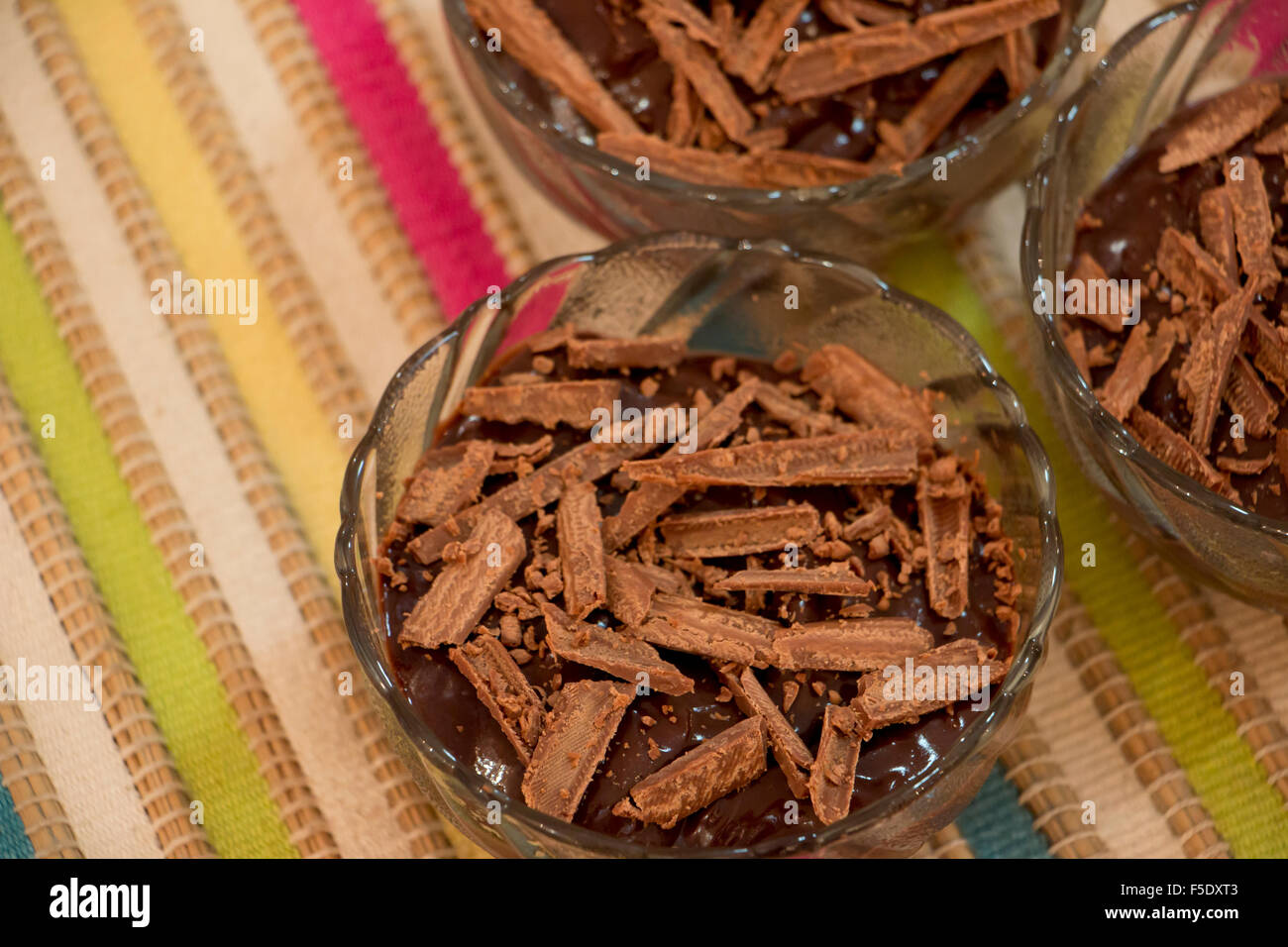 Budino di cioccolato in una ciotola di vetro con un cioccolato grattugiato sulla parte superiore. Foto Stock
