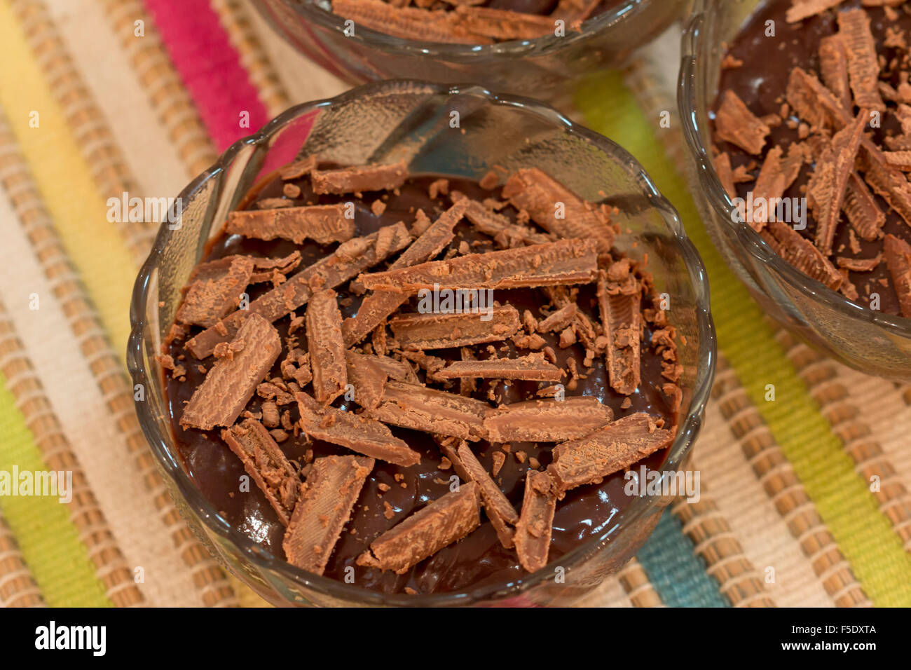Budino di cioccolato in una ciotola di vetro con un cioccolato grattugiato sulla parte superiore. Foto Stock